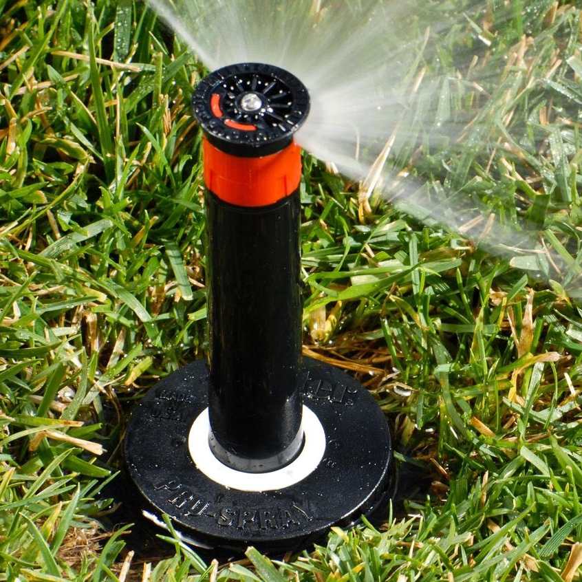 Pop-up rotor head spraying across a lawn